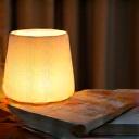 Noční lampička na straně postele s knihou, evokující klidný večerní rituál před spaním